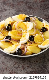 Oriental salad is a favorite of Romanians potato salad with onions, olives and boiled eggs close-up on a plate on the table. Vertical - Shutterstock ID 2189814135