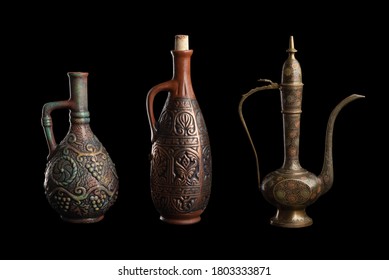Oriental vases decorated with patterns and ornaments. Objects made of different materials. Old, kitchen utensils on a black isolated background.