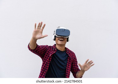 Oriental Young Man Having Fun With Vr Glasses Against A Blue Sky And Clouds - Social Influencer Playing With New Trends Tech Opportunities - Metaverse, Fictional World And Virtual Reality Concept