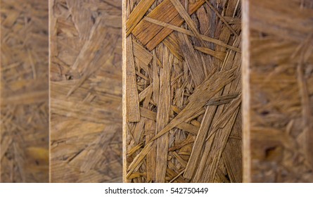Oriented Strand Board. Building material. Wooden panel made of pressed sandy brown wood shavings as background closeup