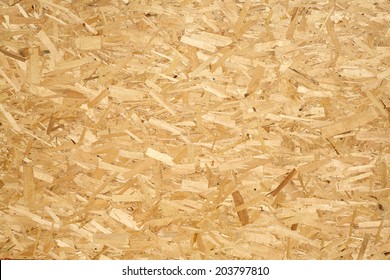 Oriented Strand Board. Chipboard building material. OSB wooden panel made of pressed sandy brown wood shavings as background closeup - Shutterstock ID 203797810