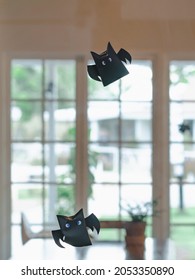 Origami Bat Made Of Black Paper Hanging On A Rope For Halloween Decorations. Dark Paper Ghost Halloween Party Concept Origami Paper Bat. The Figure Of Black Paper Bat Flying Over Room. Selective Focus