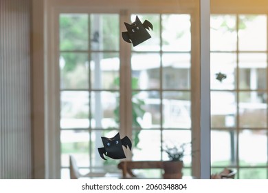 Origami Bat Made Of Black Paper Hanging On A Rope For Halloween Decorations. Dark Paper Ghost Halloween Party Concept Origami Paper Bat. The Figure Of Black Paper Bat Flying Over Room. Selective Focus