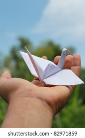 Origami Bird On The Hand With Blue Sky.