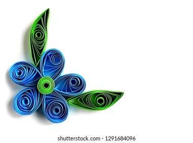 Origami blue flower & paper green leaves frame in quilling technique. Beautiful origami paper flower with leaves - quilling art element. Handmade kids quilling origami flower & leaves from color paper