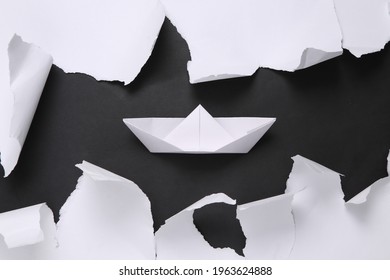 Origami Boat On Black Background With White Torn Paper. Concept Art. Minimalism. Top View