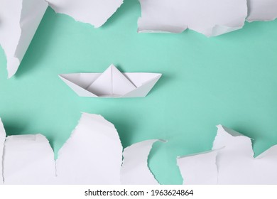 Origami Boat On Blue Background With White Torn Paper. Concept Art. Minimalism. Top View