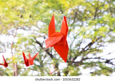 Origami crane on tree background, Orange paper bird - Powered by Shutterstock