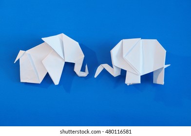 Origami elephant out of paper isolated on a colored background
