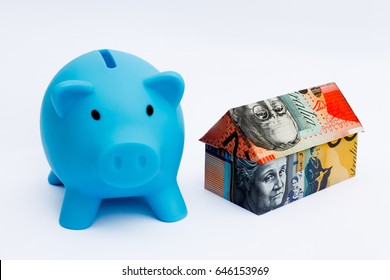 Origami Money House Next To A Blue Piggy Bank