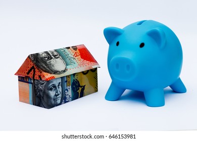 Origami Money House Next To A Blue Piggy Bank