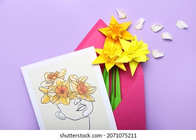 Origami narcissus flowers, envelope and greeting card on color  background