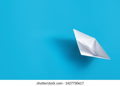 Origami Paper Boat On Blue Background, View From Top, Copy Space.