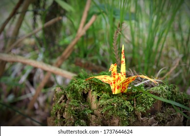 Origami paper crane with yellow and red butterfly patterns - Powered by Shutterstock