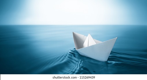 Origami Paper Sailboat Sailing On Blue Water