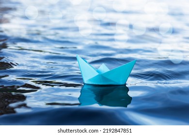 Origami Paper Sailboat Sailing On Blue Water