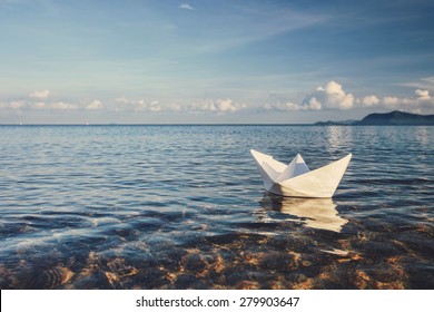 Origami Paper Sailboat Sailing On Blue Water