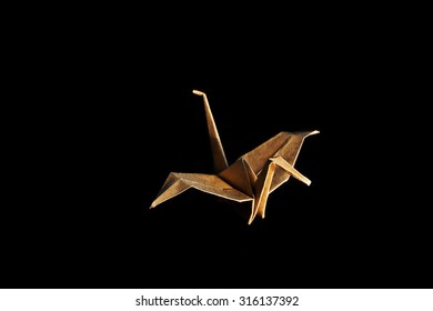 Origami recycle paper crane on wooden background with shadow.