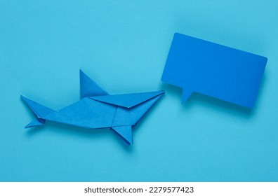 Origami shark with empty speech bubble on blue background