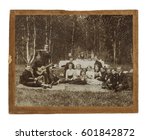Original antique photo of the early 20th century of a group of seventeen  people at the picnic in Siberia in Russia on the table background with serious granny and samovar with tea.