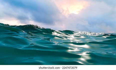 Original beautiful image of the nature of the sea element - waves with glare from sunlight against the background of clouds covering sun. - Powered by Shutterstock