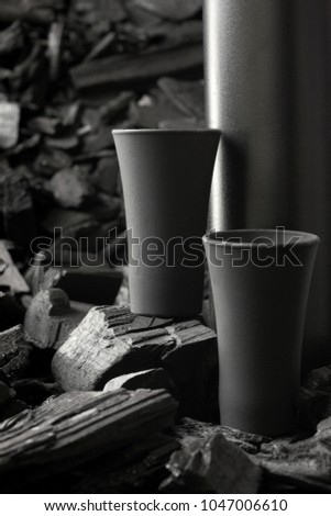 Original black matte bottle of vodka or tequila and black shot glass .On charcoal background. Black edition.Creative.Let's drink.Cheers.Mockup.Copy space.Pour it.Still life