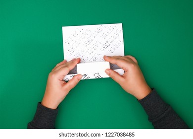 The original design of a Christmas gift made of white paper with handwritten text written with a marker. Step by step on the photo. Handmade, DIY. White paper wrapped gift with text. - Powered by Shutterstock