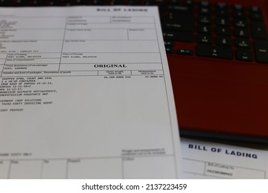 Original document paper Bill of Lading or BL is a document issued by a carrier (or their agent) to acknowledge receipt of cargo for shipment with keyboard laptop as background