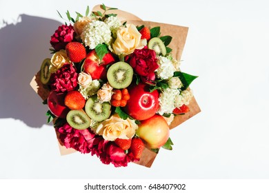 The original edible bouquet of marshmallow, apples, strawberries and flowers on white. Top view