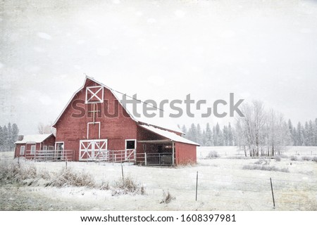 Original textured vintage style photograph of an old red barn on a winter day in snow