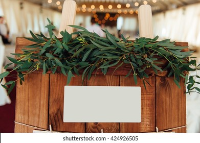 Original vintage wooden board with decoration and ribbons and a guest list, heart and bucket in the background. with a place for an inscription