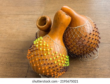 Originated in south west of Nigeria, shekere is a West African percussion instrument consisting of a dried gourd with beads or cowries woven into a net covering the gourd.