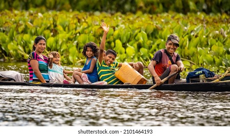 Orinoco, Venezuela - 11-23-2021: Native Orinoco tribe people in traditional boat in Venezuela waving at camera