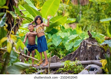 Orinoco, Venezuela - 11-23-2021: Pair Of Triibal Native Orinoco River Kids Waving In Venezuela Rainforest