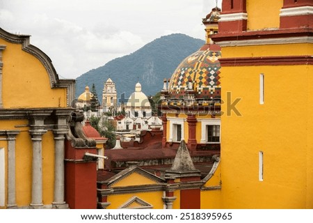 Orizaba, Veracruz, Mexico - July 14, 2022: Surrounded by mountains, cloudy sun shines on the historic core and churches of downtown Orizaba.