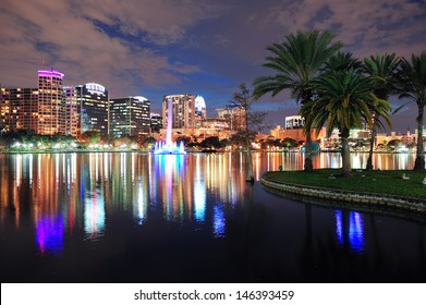 Orlando downtown skyline over Lake Eola at dusk with urban skyscrapers and lights.