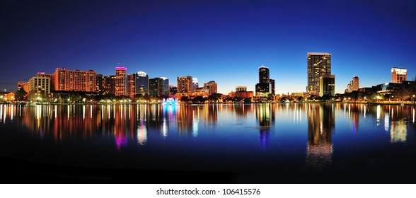 Orlando Downtown Skyline Panorama Over Lake Eola At Night With Urban Skyscrapers And Clear Sky.