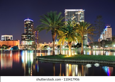 Orlando downtown skyline panorama over Lake Eola at night with urban skyscrapers, tropic palm tree and clear sky. - Powered by Shutterstock