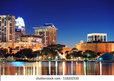 Orlando Downtown Skyline Panorama Over Lake Eola At Night With Urban Skyscrapers And Clear Sky.