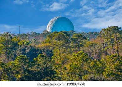 Orlando, Florida. January 12, 2019 Partial view of sphere and forest trees on light blue sky cloudy background at Lake Buena Vista area.