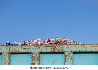 Orlando, Florida - October 10, 2021: A Pile Of Used Beer And Soda Cans Fills An Industrial Metal Dumpster At A Recycling Facility.