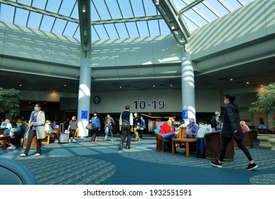 Orlando, Florida, U.S.A - February 21, 2021 - The Busy Airport Terminal With Passengers Wearing Mask Due To Coronavirus Travel Advisory