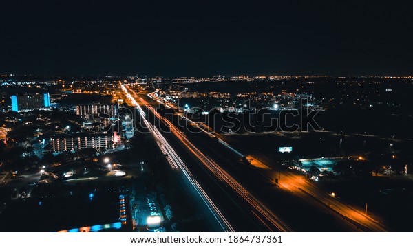 Orlando, Florida, USA - November\
28, 2020: Aerial view on Orlando, Florida at night time. Orlando\
night life, top view. Car lights tracks with long exposure\
effects