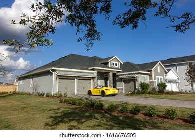 Orlando, FL/USA-1/15/20: A Stately Residential Home With An Expensive Porsche Spyder In The Driveway.  Concept Wealth And Riches.