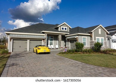 Orlando, FL/USA-1/15/20: A Stately Residential Home With An Expensive Porsche Spyder In The Driveway.  Concept Wealth And Riches.