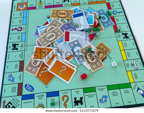 Orlando, FL/USA-12/20/19:  Pieces for the game\
Monopoly by Hasbro on a white background.  Concept business,\
banking, property, and game\
over.