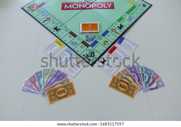 Orlando, FL/USA-12/20/19:  Pieces for the game
Monopoly by Hasbro on a white background.  Concept business,
finance, banking, real estate, and
property.