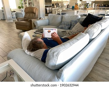 Orlando,FL USA - January 25, 2021:  A Senior Man Reading The News On His IPad While Laying On The Couch.