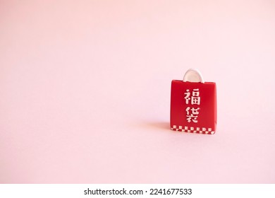 An ornament of red lucky grab bag which is a bag filled with unknown goods for fun and surprise sold during New Year celebration in Japan. (Translation of 福袋: Lucky grab bag)