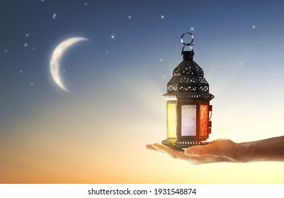 Ornamental Arabic lantern with burning candle glowing in hand. Festive greeting card, invitation for Muslim holy month Ramadan Kareem. - Shutterstock ID 1931548874